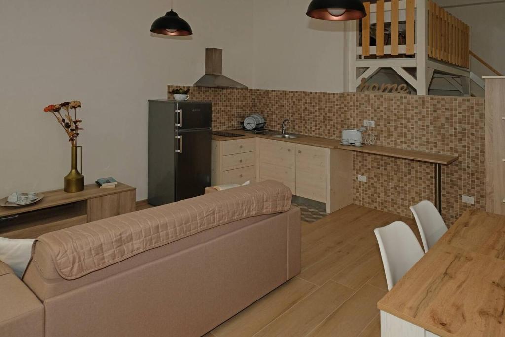 ein Wohnzimmer mit einem Sofa und einer Küche in der Unterkunft CivicoDieci in Locorotondo