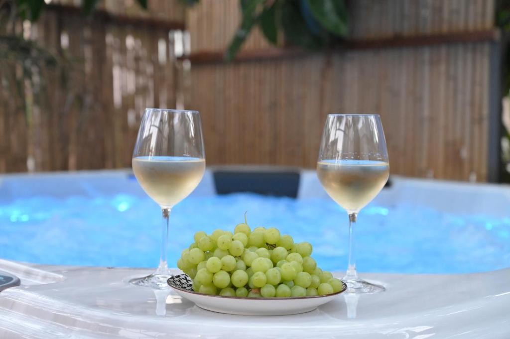 two glasses of white wine and a plate of grapes at Villa Val-Gio in Ermoupoli