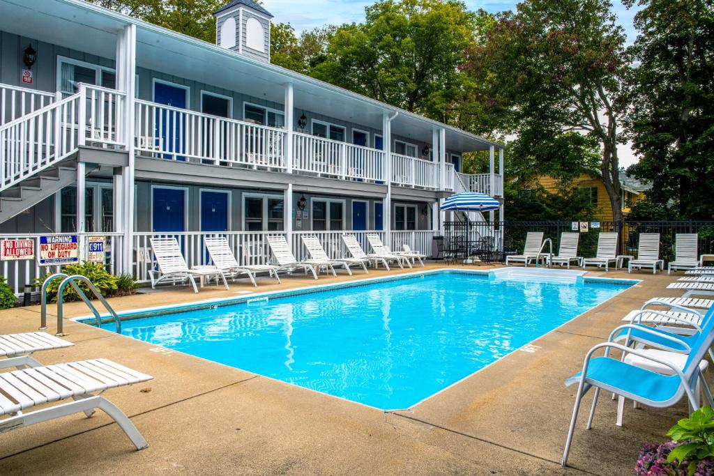 a swimming pool in front of a hotel with chairs at Stage Run by the Sea in Ogunquit