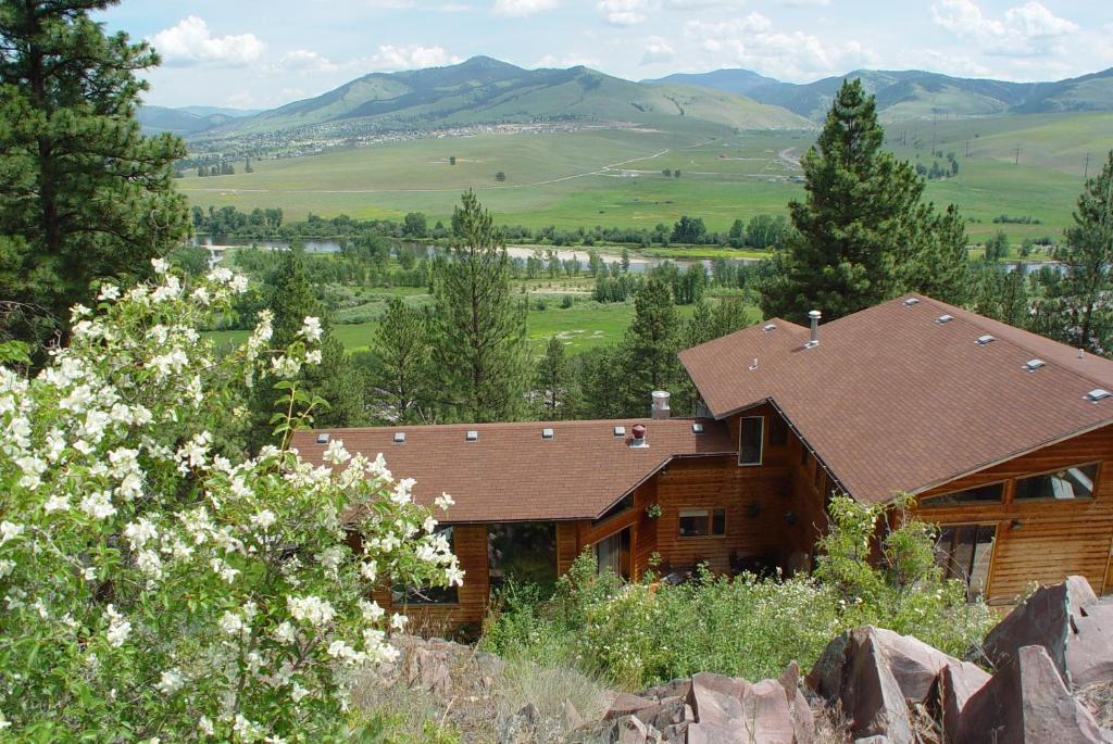 a wooden house with a mountain in the background at Blue Mountain Bed and Breakfast in Lolo