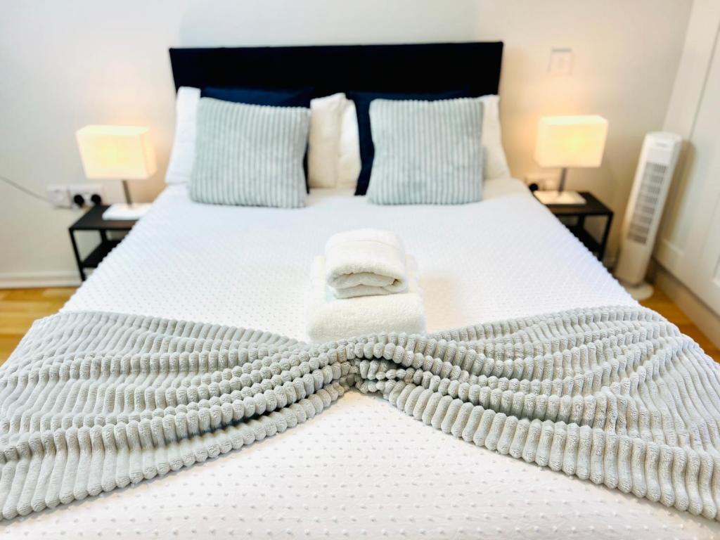 a bed with two towels on top of it at Modern Apartment at Temple Bar with River View in Dublin