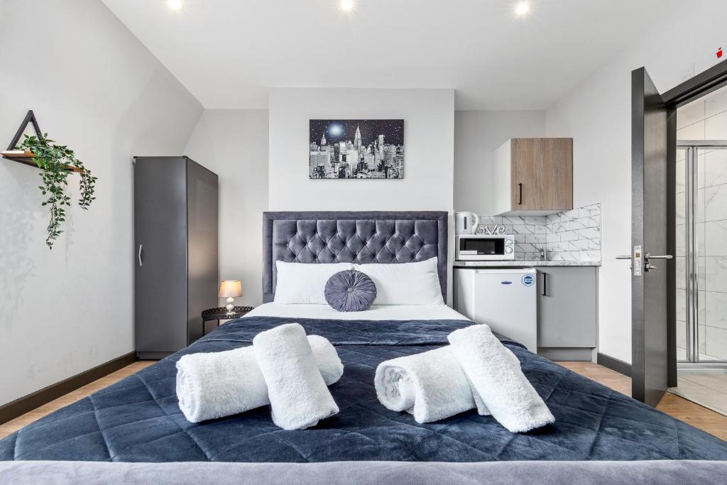 a bedroom with a large bed with two white towels at Sydenham Stays by Hayes Residency in London