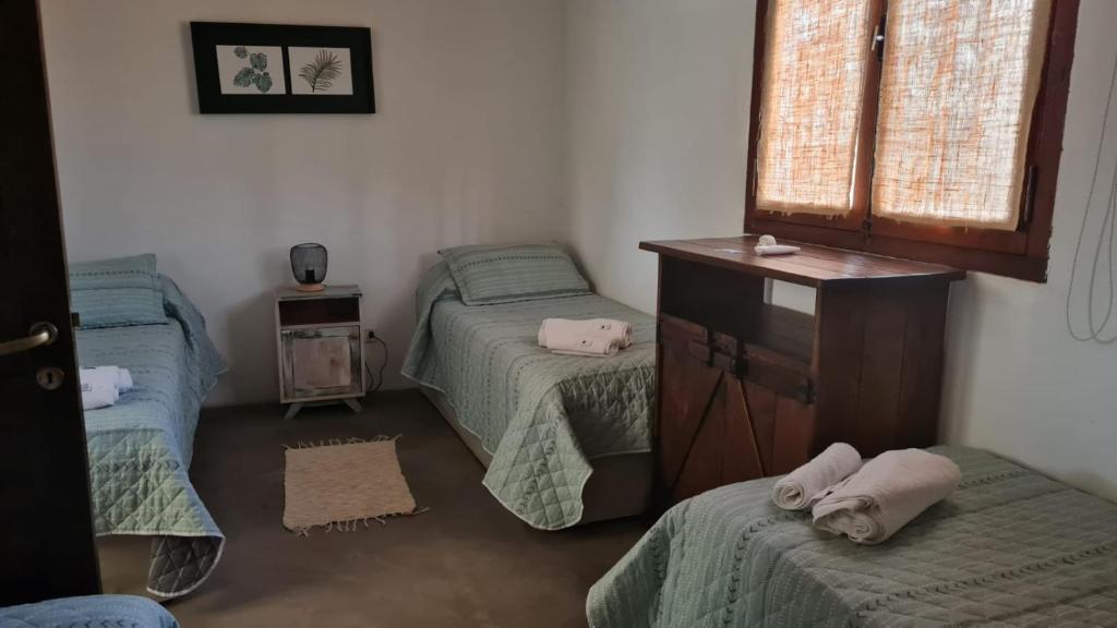 a bedroom with two twin beds and a dresser at CASA CAFAYATE LA SOÑADA in Cafayate