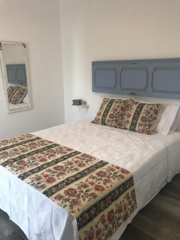 a bedroom with a large bed with a quilt on it at Casa 1-Quinta dos Penedos in Portalegre