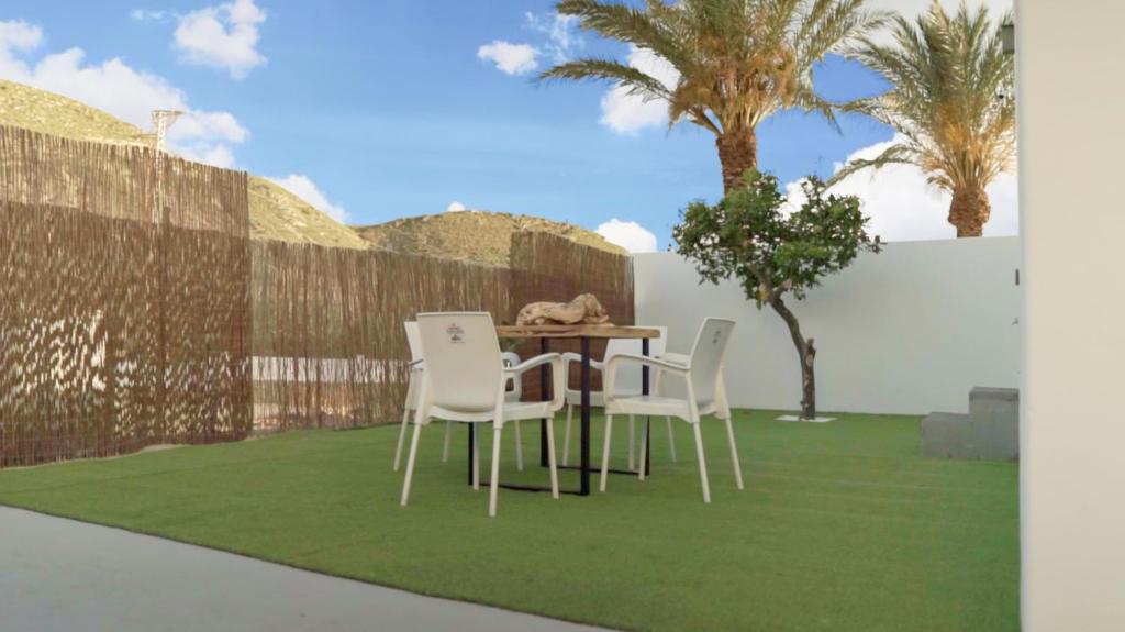 a table and chairs on a lawn with palm trees at Villa Don Paco in Las Negras