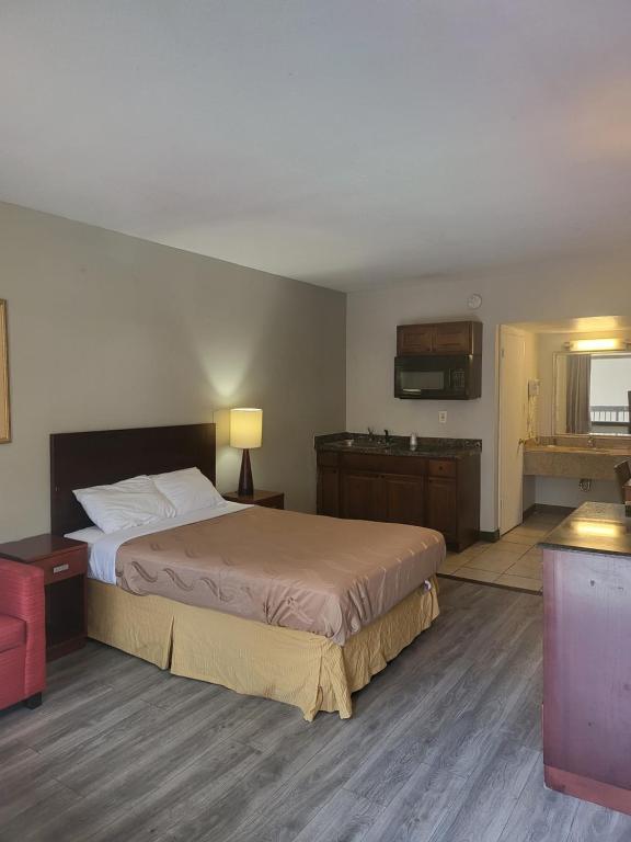 a hotel room with a bed and a kitchen at Baymont by Wyndham Williamsburg in Williamsburg