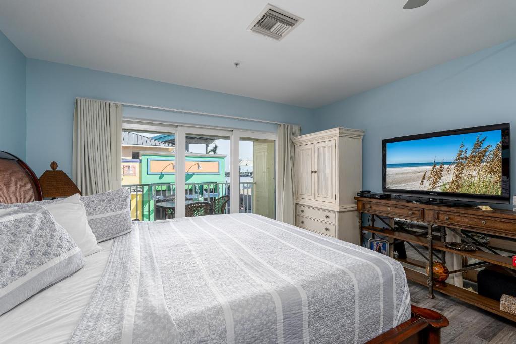 a bedroom with a bed and a flat screen tv at Harbour House stunning Studio in Fort Myers Beach