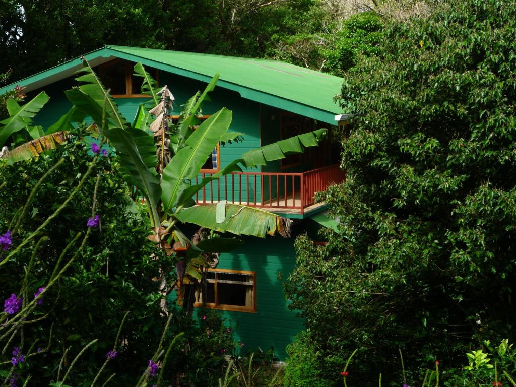 Casa azul con techo verde y balcón en Hospedaje Mariposa, en Monteverde