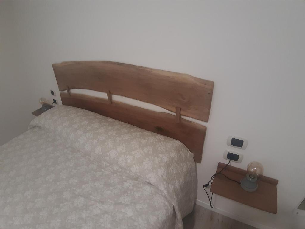 1 dormitorio con 1 cama con cabecero de madera en Civico 7, en San Giacomo degli Schiavoni