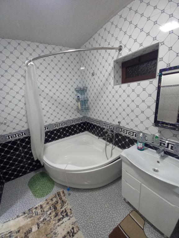 La salle de bains est pourvue d'une baignoire, de toilettes et d'un lavabo. dans l'établissement UYUT INN Hotel, à Samarcande