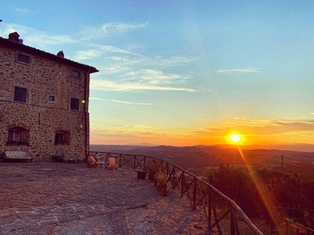 a building on a hill with the sunset in the background at Mansarda Isabella in Linari