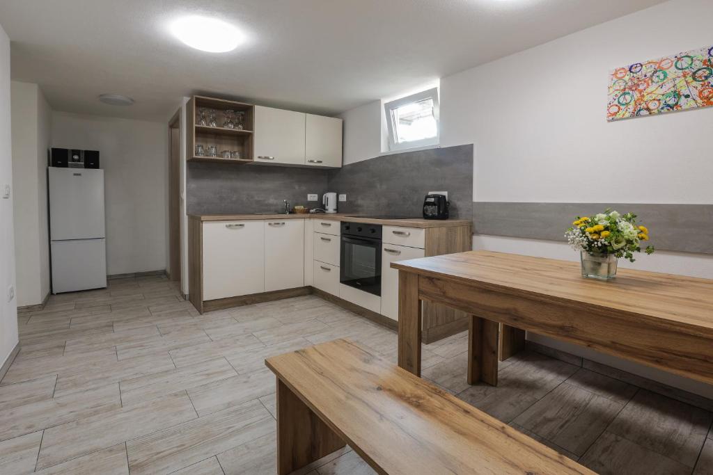 a kitchen with white cabinets and a wooden table at Apartment For You in Bled