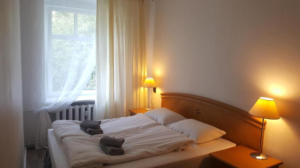 a bedroom with a bed with two pillows and a window at Švyturio papėdė in Nida