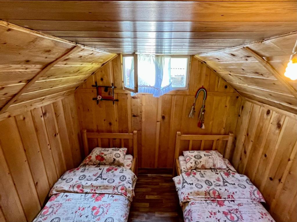 a bedroom with two beds in a wooden house at Katun Lanista-Kolibe Bogavac in Mojkovac