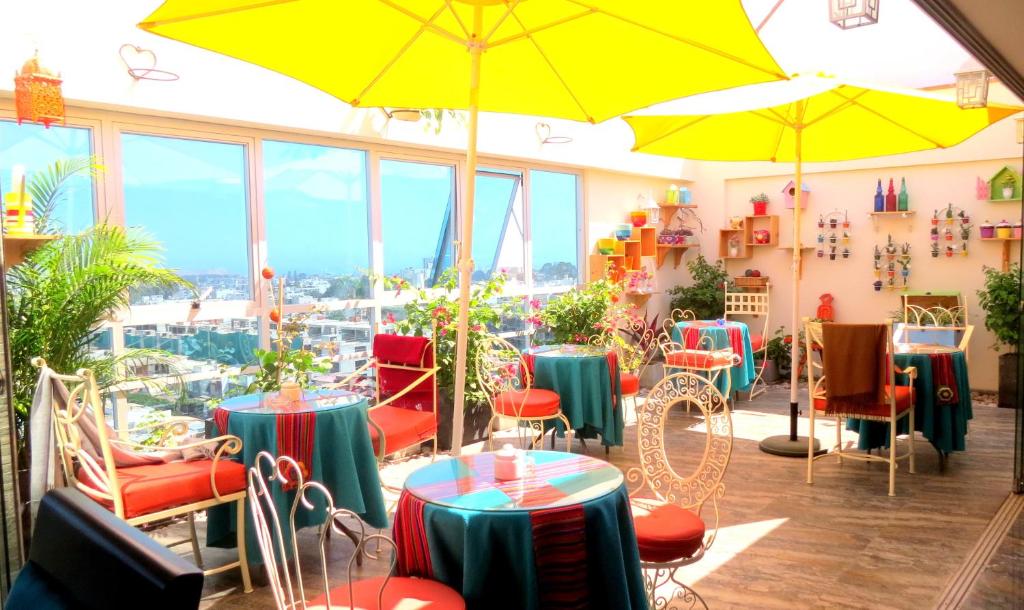 een restaurant met tafels, stoelen en parasols bij Hotel Vila Santa in Lima