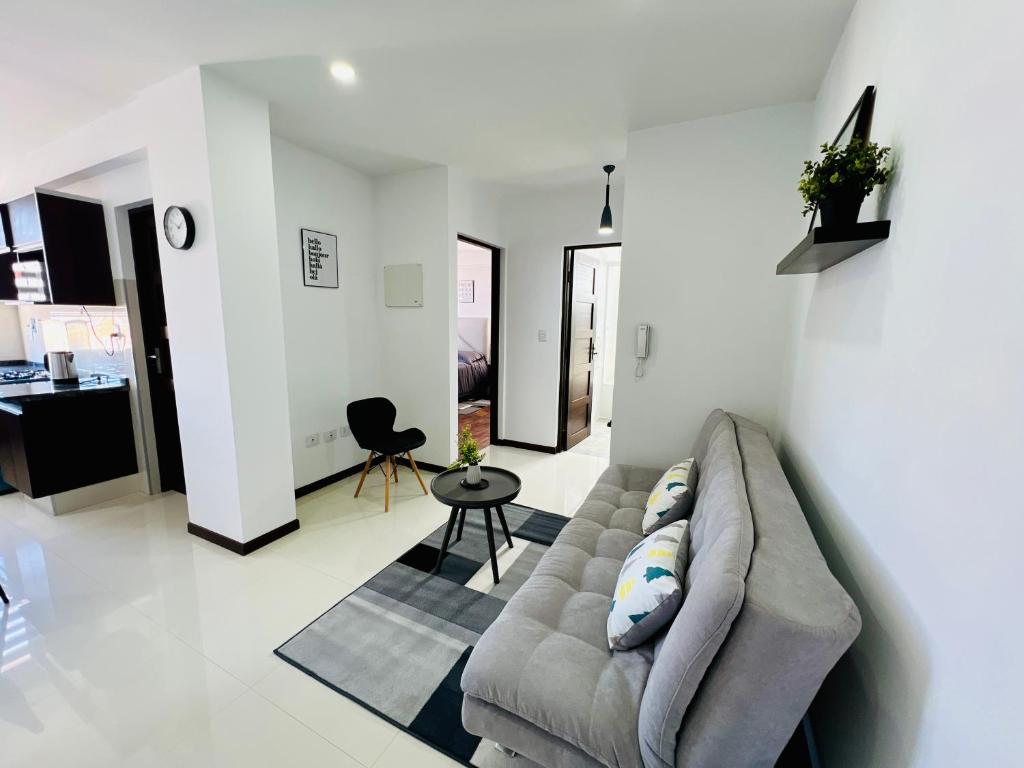 a living room with a couch and a table at Acogedor departamento en el corazón de cochabamba in Cochabamba