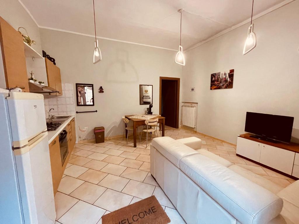 a living room with a white couch and a kitchen at TORINO LOW COST in Chivasso