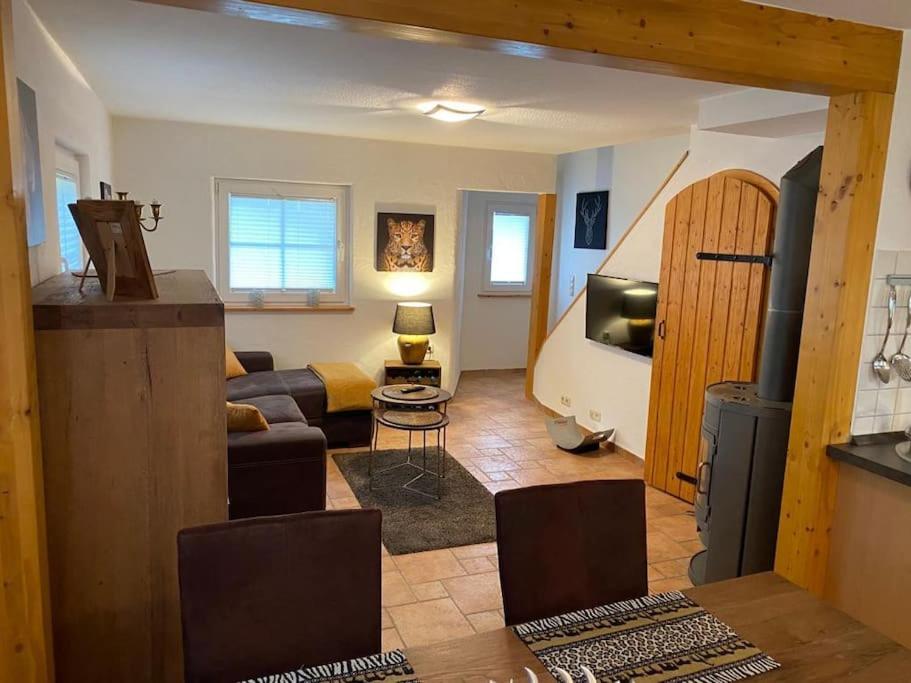 ein Wohnzimmer mit einem Sofa und einem TV in einem Zimmer in der Unterkunft Waldheimat - Ferienhaus Nürburg in Nürburg