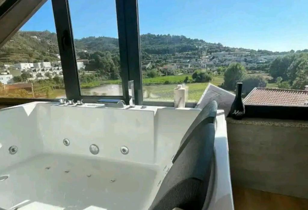 a white bath tub in a room with a window at Arrendar braga in Braga