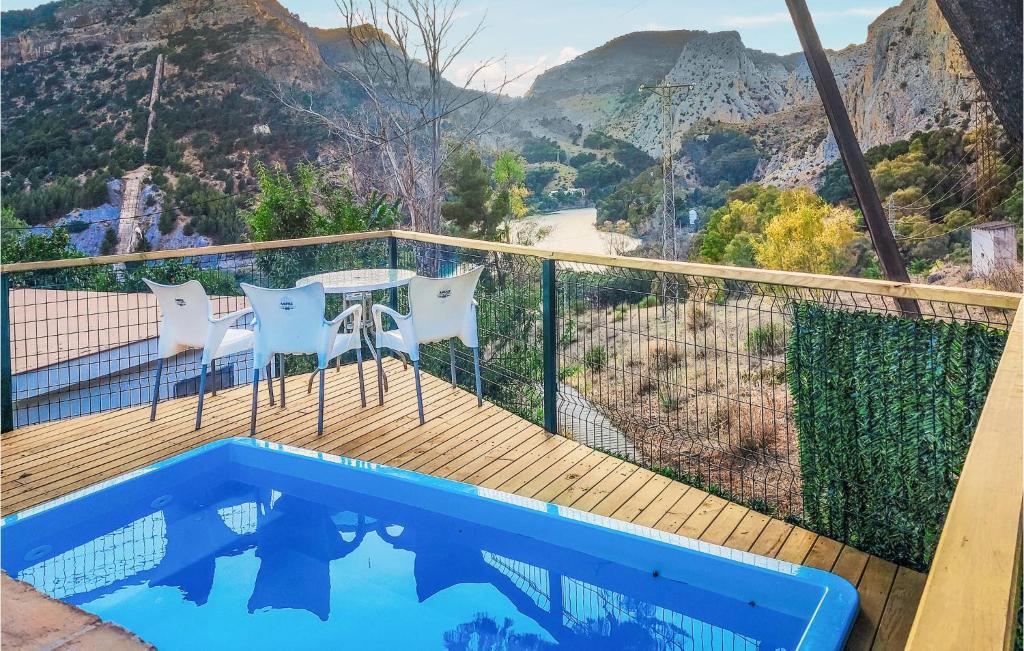 a balcony with a pool and a table and chairs at Awesome Home In Malaga With Wifi, 2 Bedrooms And Outdoor Swimming Pool in Málaga