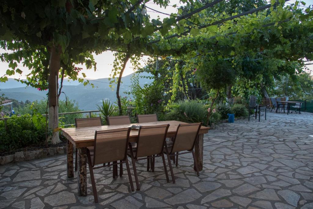 a wooden table and chairs on a patio at metaxas house in Mikros Gialos
