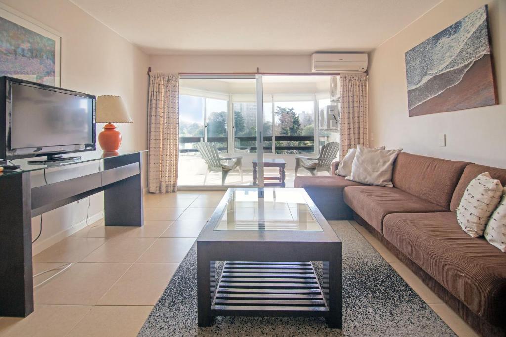 a living room with a couch and a tv at Oceana Suites BoraBora in Punta del Este