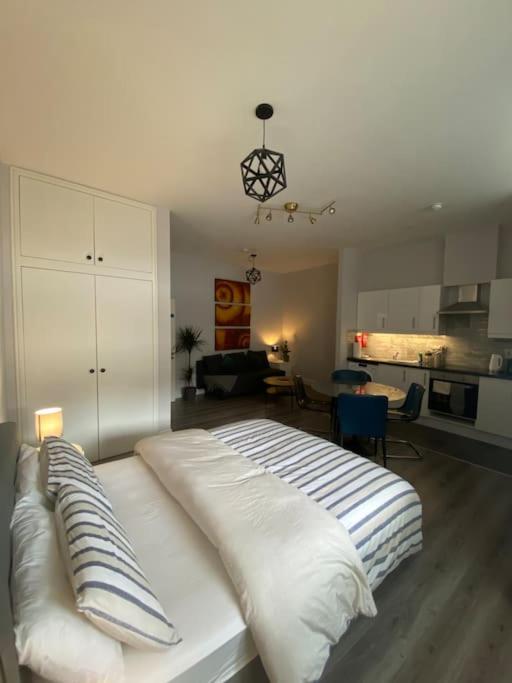 a white bed with pillows on it in a living room at City Centre Studio Apartment in Dublin