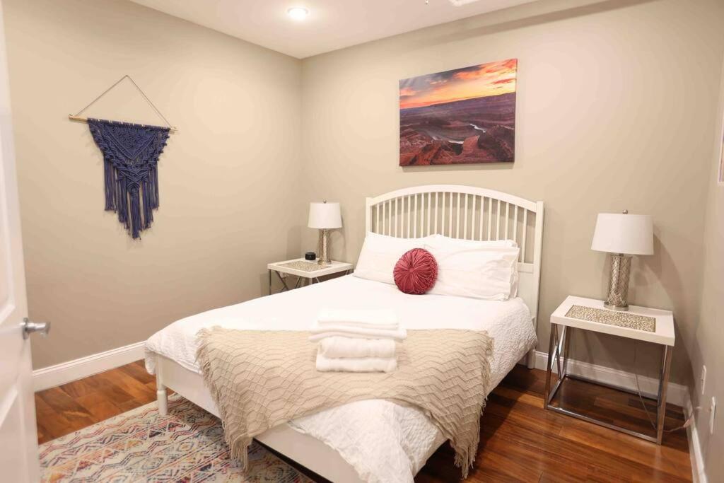 ein Schlafzimmer mit einem weißen Bett mit zwei Tischen und zwei Lampen in der Unterkunft 504 Luxe 1BDR APT in center city in Philadelphia