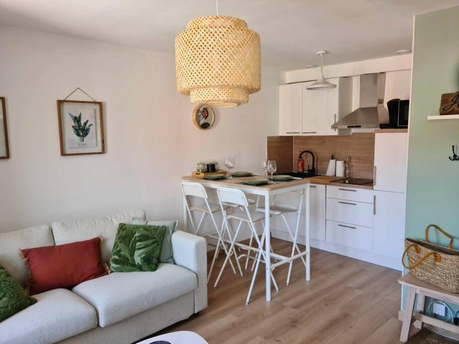 a living room with a couch and a kitchen at Les Coteaux de Mahé in Tournon-sur-Rhône