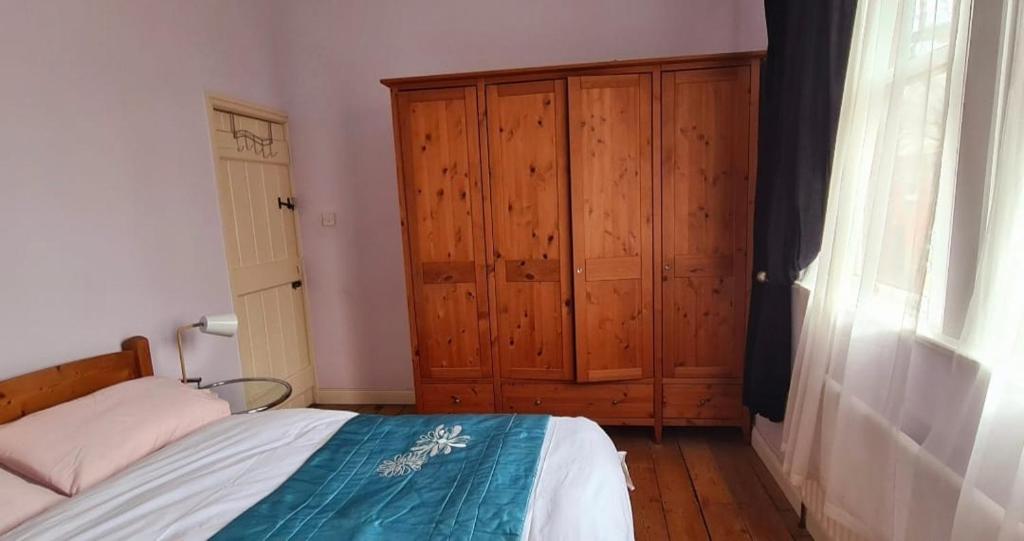 um quarto com uma cama e um armário de madeira em 20 Gray Street em Dublin