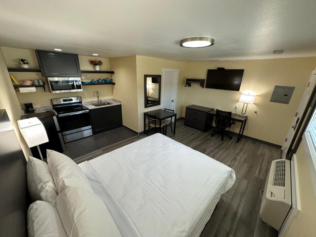 a living room with a white bed and a kitchen at Relax Inn of Medford in Medford