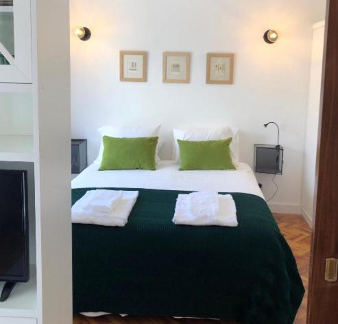 een slaapkamer met een bed met twee handdoeken erop bij NEW APARTMENT ON THE BEACH ( 100 METERS DISTANCE) in Cascais