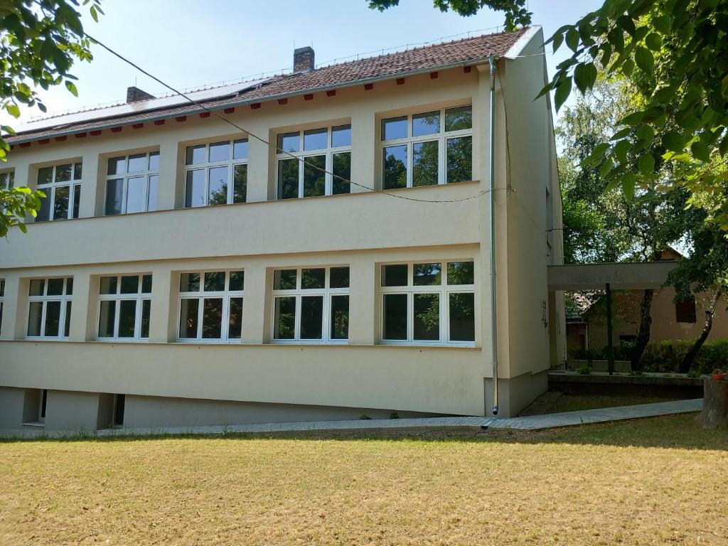 a house with large windows and a yard at Márianosztrai Zarándokszálláshely in Márianosztra