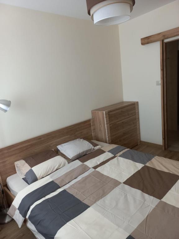 a bedroom with a large bed with a checkered floor at Apartament 7 Piętro in Bydgoszcz