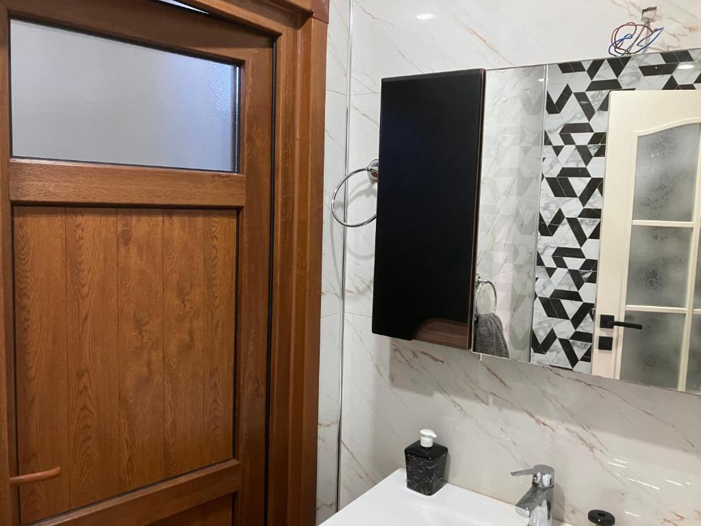 a bathroom with a sink and a door and a mirror at Önder suit in Rize