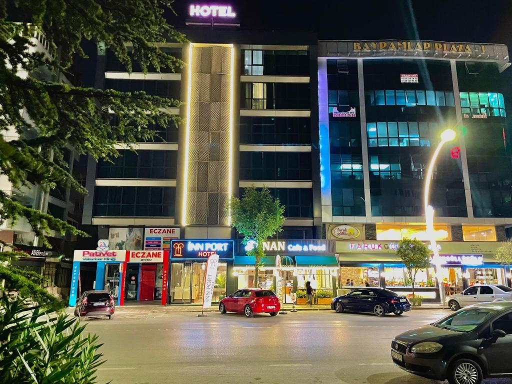 eine Stadtstraße mit Autos, die vor einem Gebäude geparkt sind in der Unterkunft İNNPORT HOTEL in Gebze