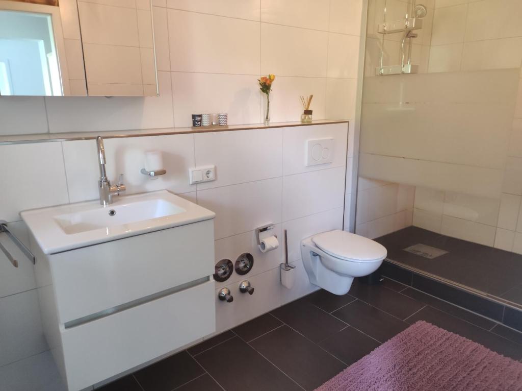 ein weißes Bad mit einem Waschbecken und einem WC in der Unterkunft Ferienwohnung Lange in Brilon