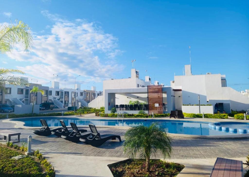 una piscina con tumbonas frente a un edificio en Renta vacacional, en Playa del Carmen