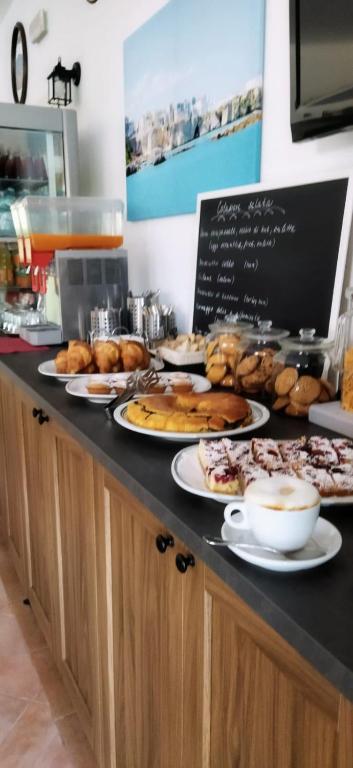 a counter with plates of pastries and other food at Hotel Residence Villa Ascoli in Vieste