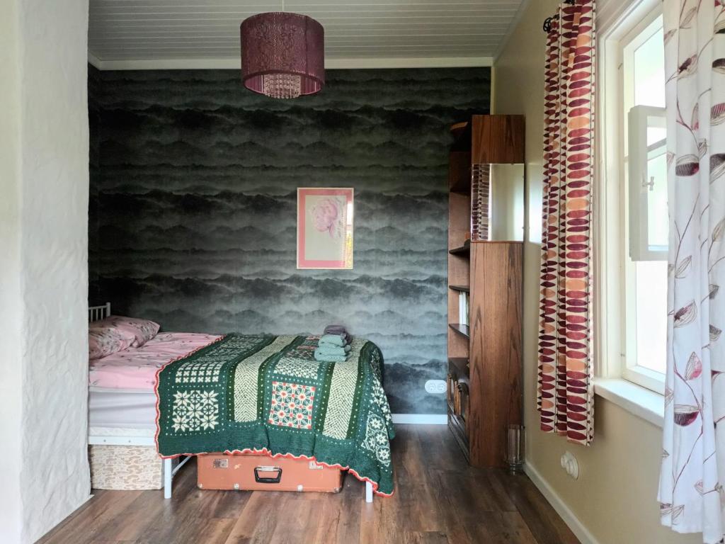 sypialnia z łóżkiem z zielonym kocem w obiekcie Sallimeister Linda külalistemaja. w mieście Haapsalu