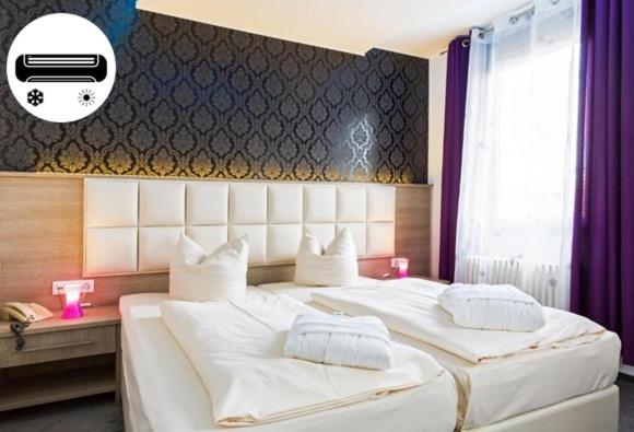 Bavaria Hotel Münchner Hof Superior في شتوتغارت: غرفة نوم بسريرين مع شراشف بيضاء