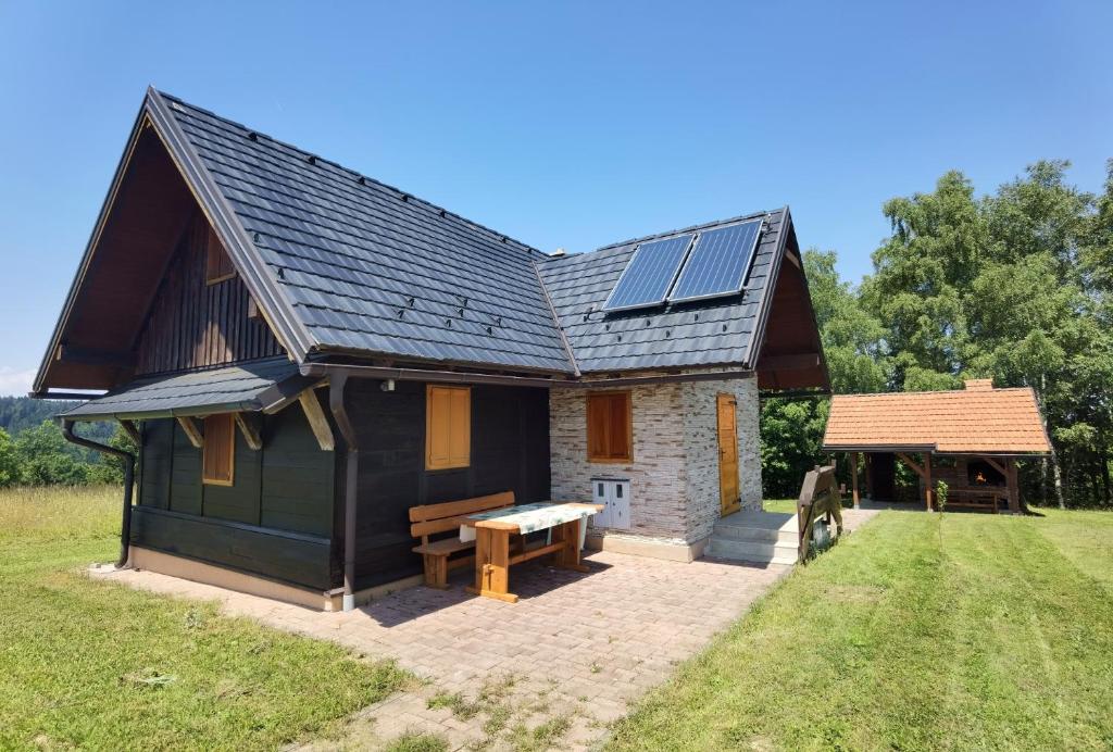 una piccola casa con pannelli solari sul tetto di Mountain Hut Stara Hiša a Kupjak