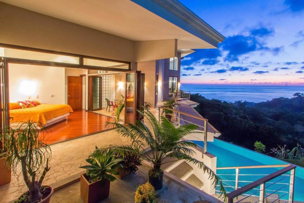 a bedroom with a bed and a view of the ocean at Colores del Viento in Uvita