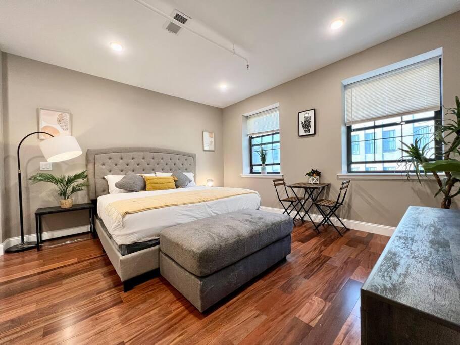 Schlafzimmer mit einem Bett, einem Stuhl und Fenstern in der Unterkunft 508 Urban Lifestyle king bed APT in Center CITY in Philadelphia