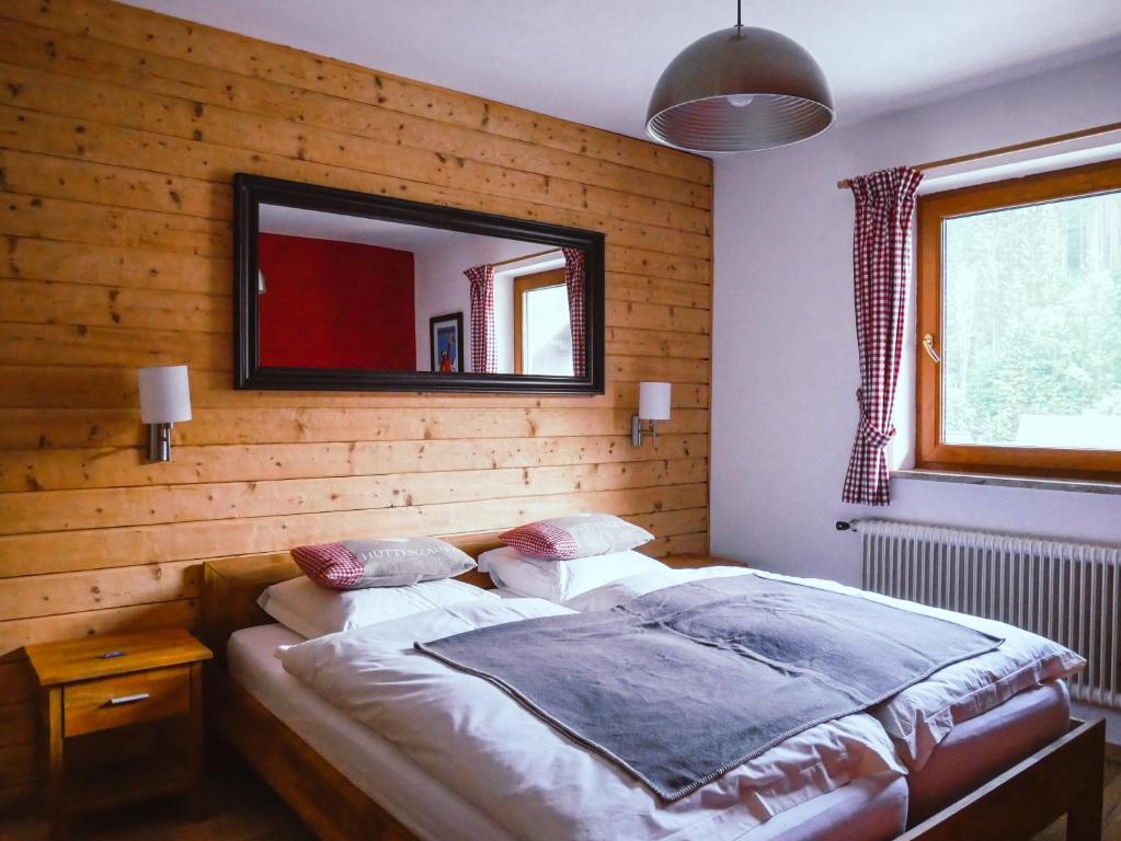 een slaapkamer met een bed met een spiegel aan de muur bij Haus Wasserbauer in Mühlbach am Hochkönig