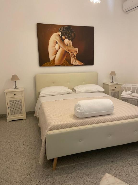 een slaapkamer met een bed met een schilderij aan de muur bij Villa Dei Fiori in Locorotondo