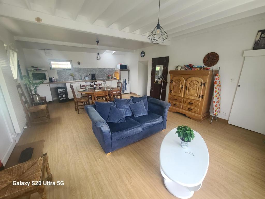 a living room with a blue couch and a table at Les chambrées du bac in Charly-sur-Marne