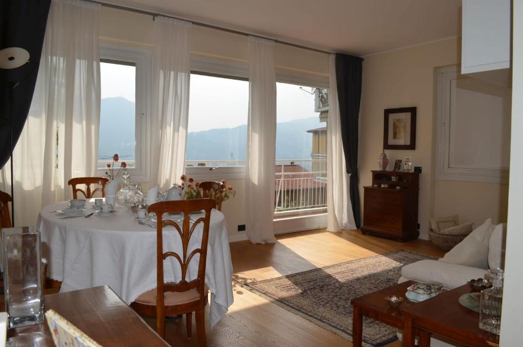 ein Esszimmer mit einem Tisch und einem großen Fenster in der Unterkunft B&B Paradisett in Como
