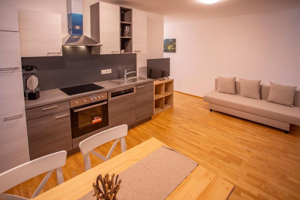 een keuken en een woonkamer met een tafel en een bank bij RESIDENZ 206 INNSBRUCK I FREE PARKING in Innsbruck