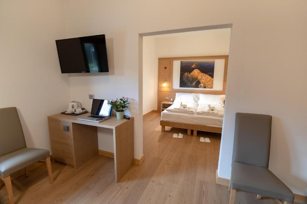 a bedroom with a bed and a desk with a laptop at Residence Panorama in Val di Zoldo